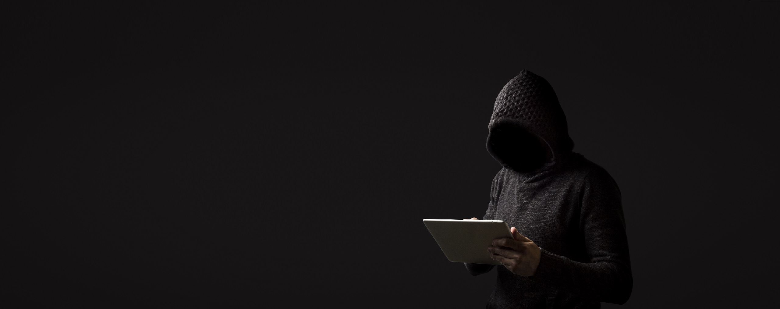 Hacker with tablet in darkness