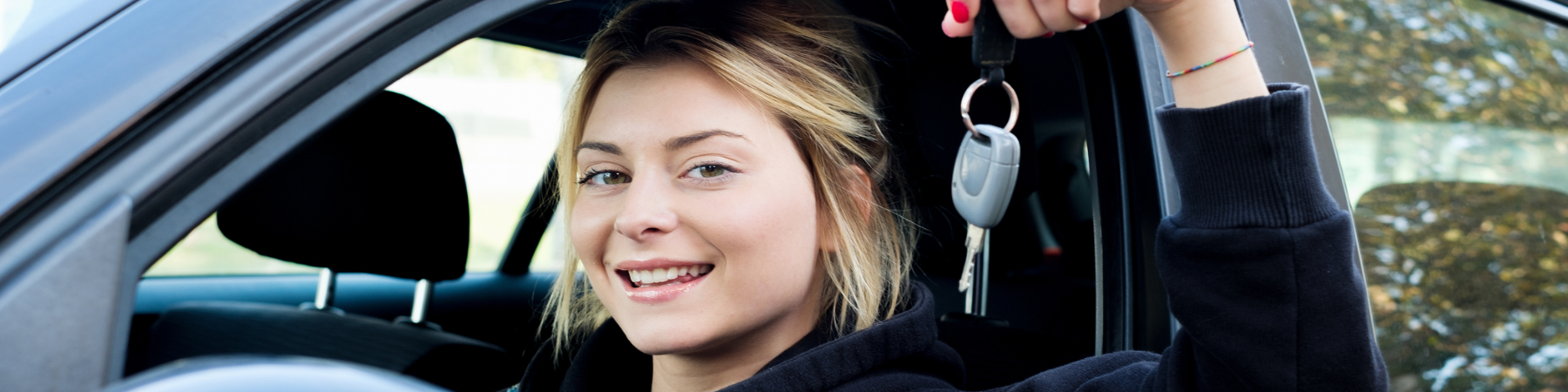 Girl holding car keys while in car